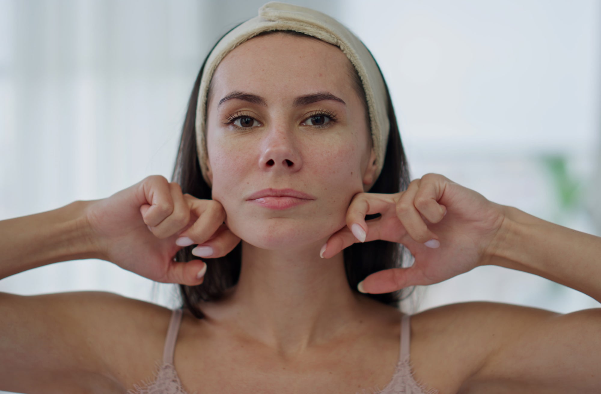 Women performing facial exercise to lose face fat